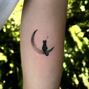 tatouage chat minimaliste dotwork assis sur une lune - Intérieur bras femme - Tattoo chez L