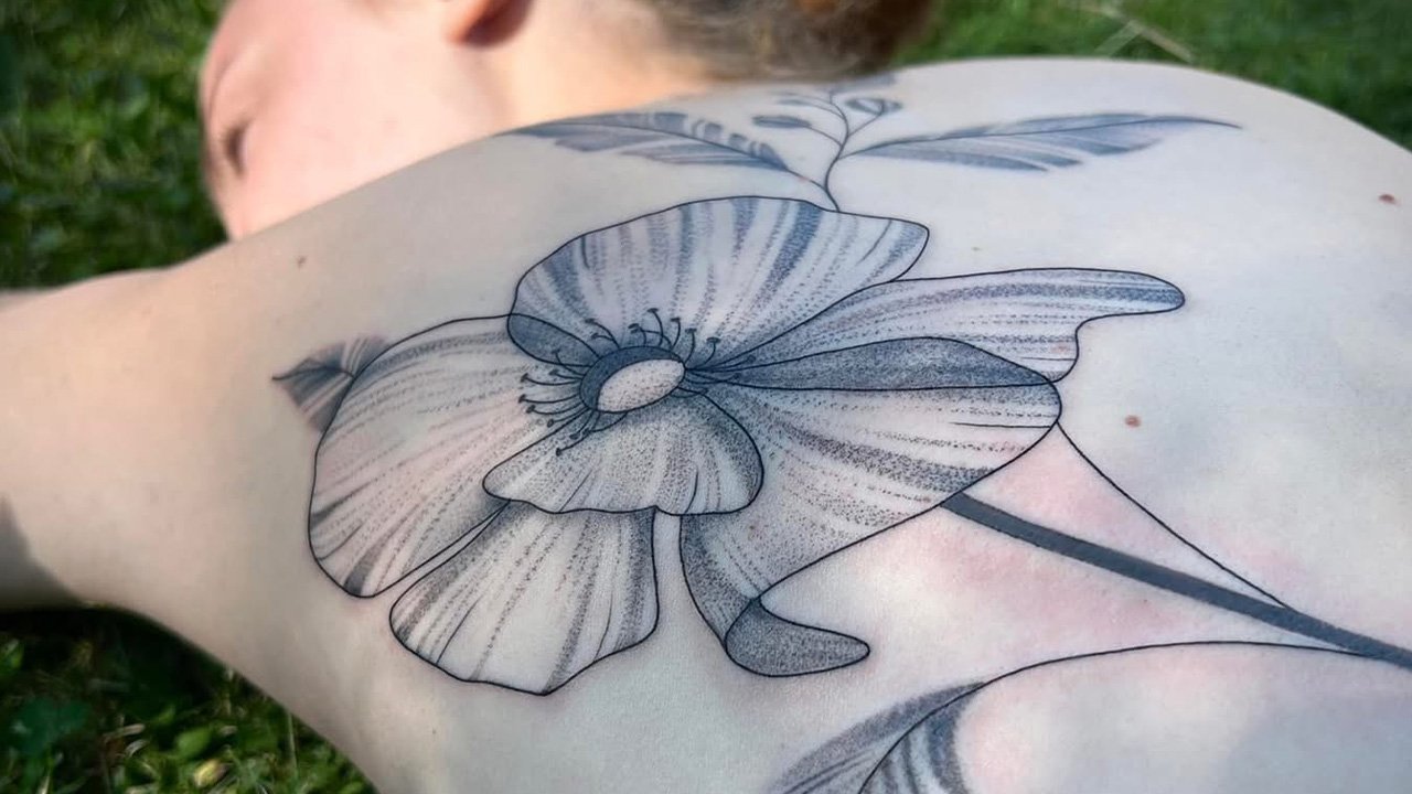 Tatouage coquelicot associé au signe du bélier tatouage coquelicot dans le dos d'une femme - Symbole du signe astrologique du bélier