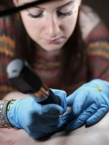 tattoo chez l en train de tatouer dans son shop à vonnas