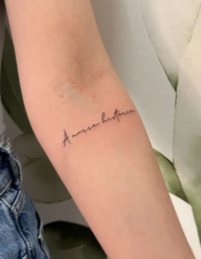 tatouage calligraphique citation italienne sur l'avant-bras intérieur d'une femme - Tattoo chez L