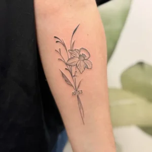 tatouage floral iris en style fine line sur l'avant bras intérieur d'une femme - Tattoo chez L