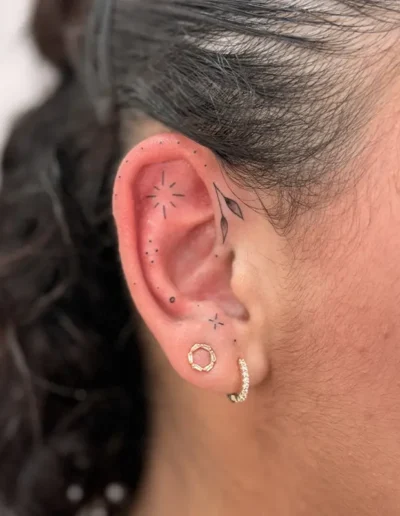 tatouage minimaliste, floral et ornemental sur l'oreille d'une femme - Tattoo chez L