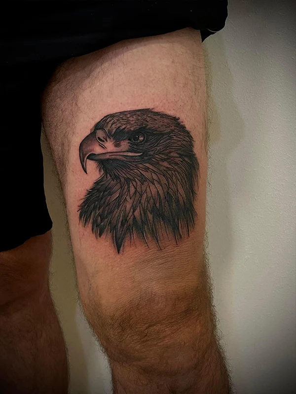 tatouage semi-réaliste d'un aigle sur le devant de la cuisse d'un homme - Tatoué par Tattoo chez L'