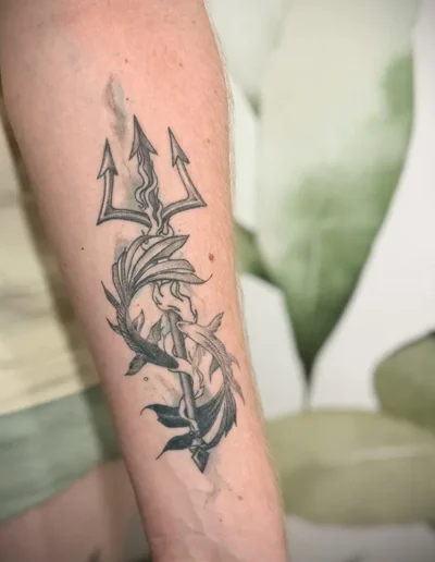 tatouage semi-réaliste de deux carpes Koï entourées autour d'une fourche du diable sur l'avant-bras d'un homme réalisé par Tattoo chez L' (vonnas)